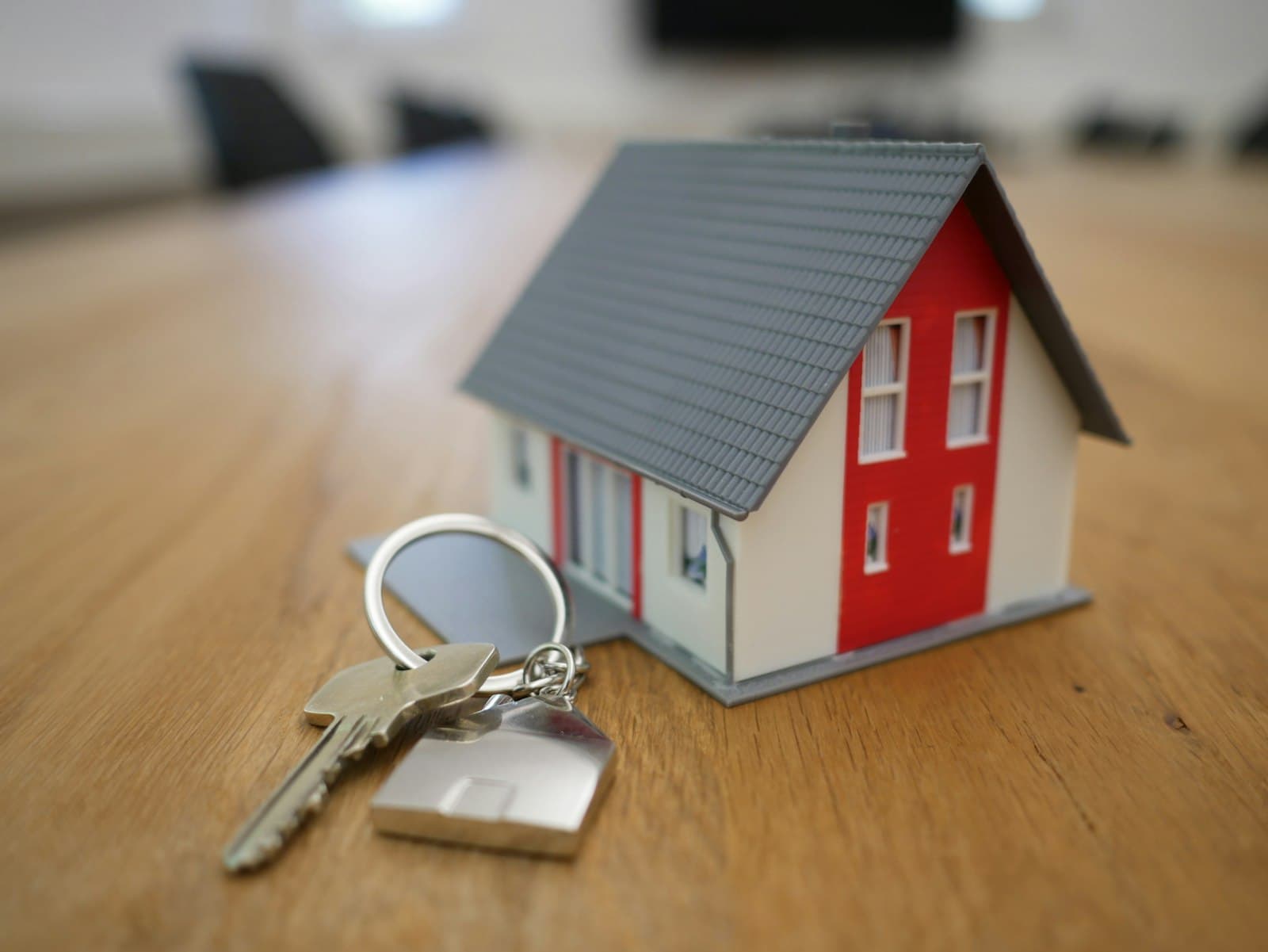 House keys beside a model home, representing a home buyer's inspection